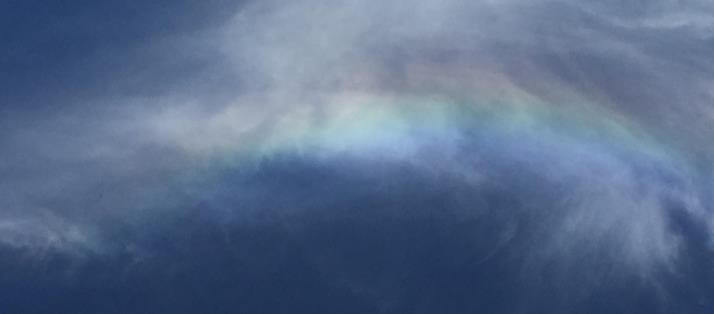 Ein feiner Regenbogen in einer dunklen Wolkenlandschaft